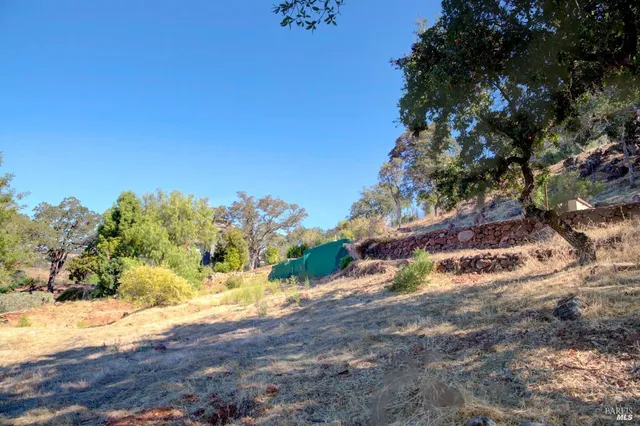 a picture of a yard and a house with wooden fence