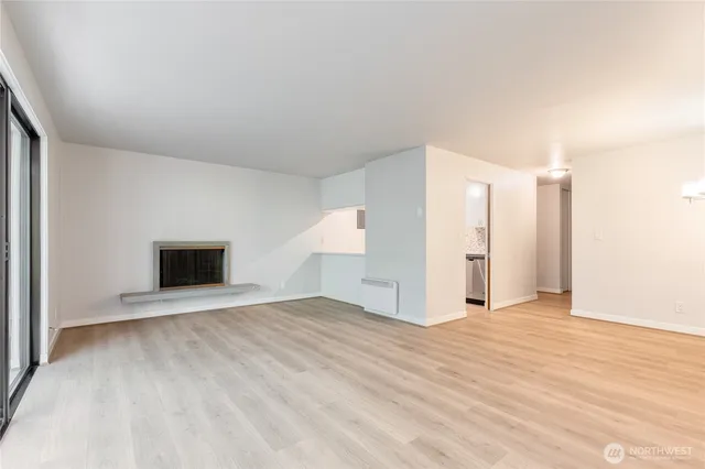 a view of an empty room with a fireplace and a window