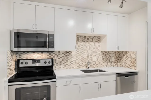 a kitchen with microwave cabinets and stove top oven