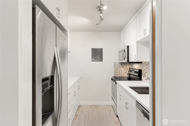 a kitchen with a sink a refrigerator and cabinets
