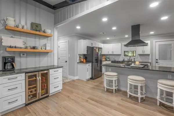 a kitchen with stainless steel appliances kitchen island granite countertop a table chairs stove and cabinets