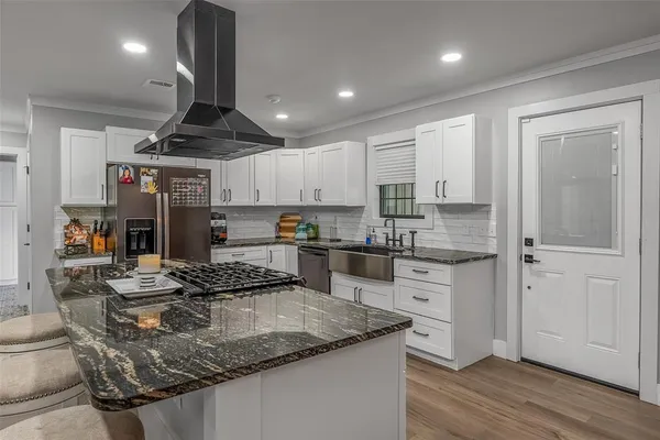 a kitchen with stainless steel appliances granite countertop a sink stove and refrigerator