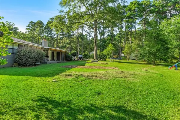 a grassy field with trees in the background