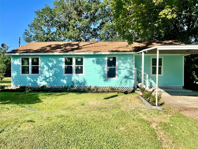 a view of a house with backyard and sitting area