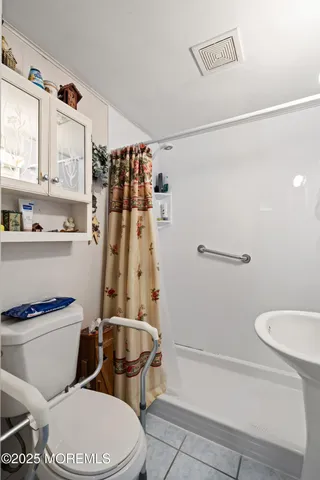 a white toilet sitting next to a bathroom sink and a shower