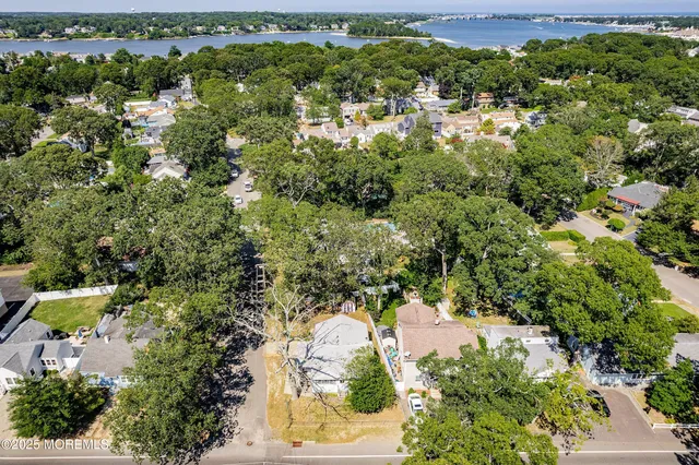 an aerial view of residential houses with outdoor space and trees
