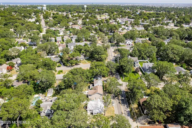 an aerial view of residential houses with outdoor space and trees
