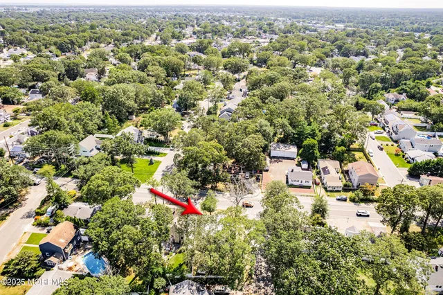an aerial view of residential houses with outdoor space and trees
