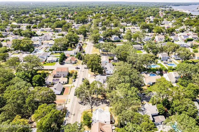 an aerial view of residential houses with outdoor space and trees