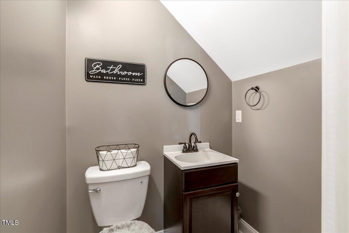 2258 Sanders Road Stem, NC 27581 - Photo 30 of 42 a bathroom with a toilet a sink and mirror