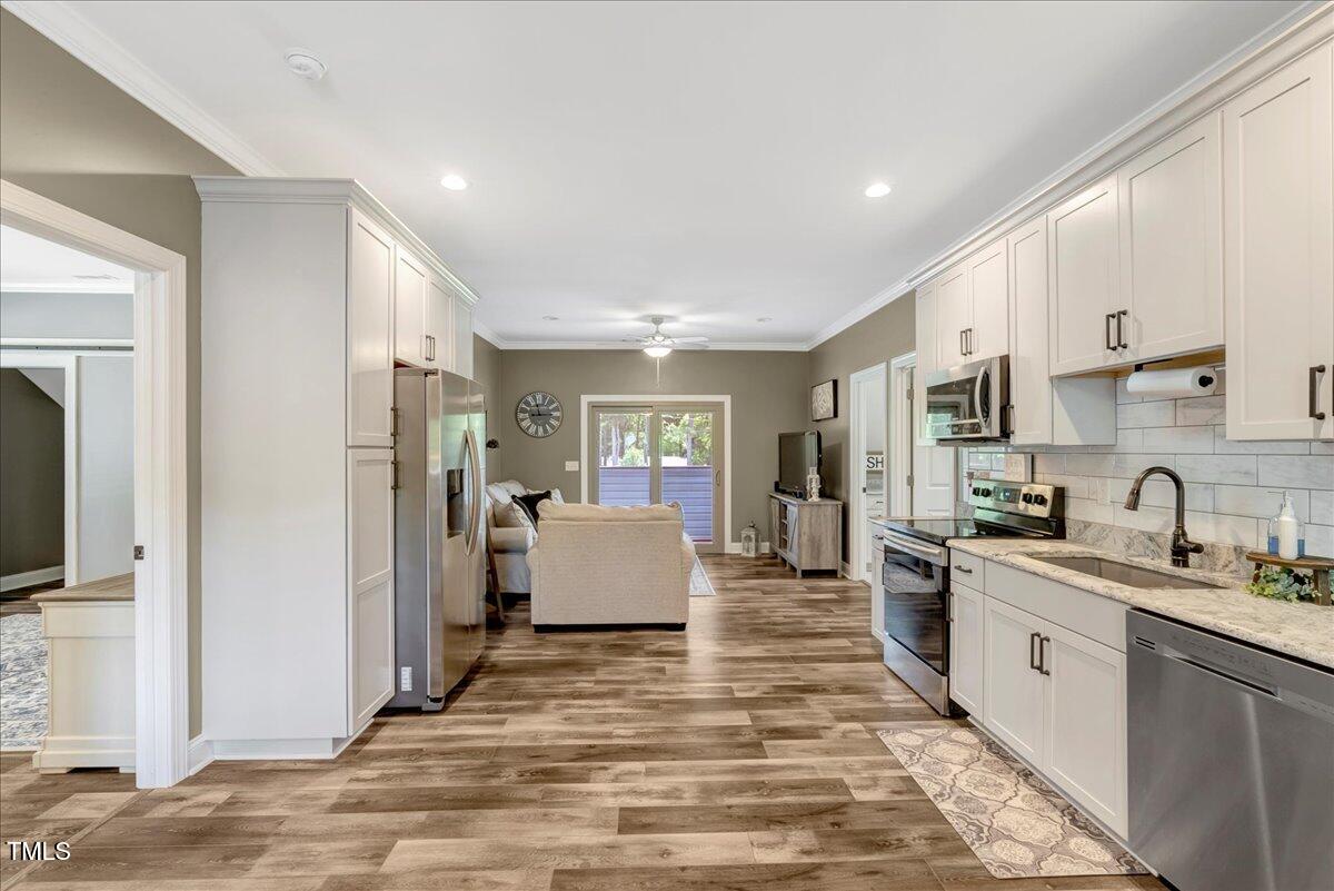 2258 Sanders Road Stem, NC 27581 - Photo 8 of 42 a large white kitchen with stainless steel appliances granite countertop a stove and a sink