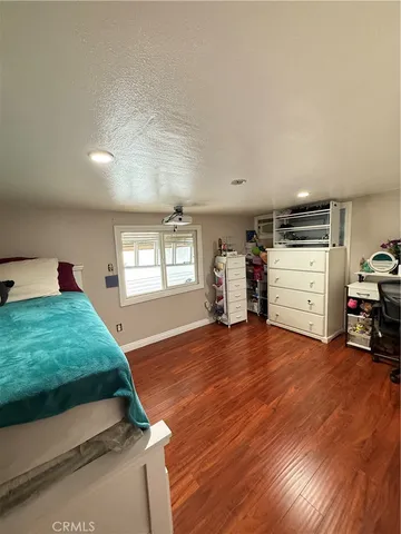 a living room with a dresser and a wooden floor