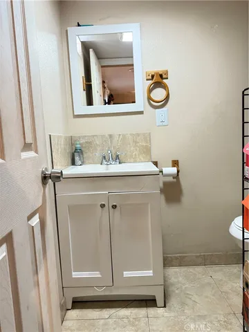 a bathroom with a sink a toilet and mirror