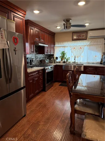 a kitchen with stainless steel appliances granite countertop a refrigerator a stove and a sink