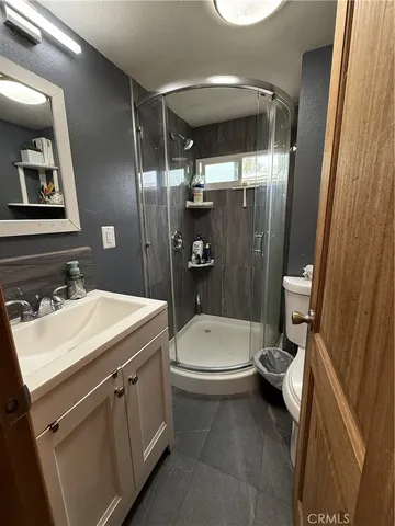 a bathroom with a sink a toilet a mirror and shower