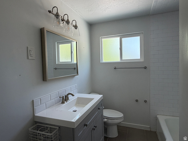 375 East 10560 South Sandy, UT 84070 - Photo 7 of 21 Bathroom featuring a gray vanity with a white countertop and integrated sink, brushed nickel faucet, subway tile backsplash, and a framed mirror