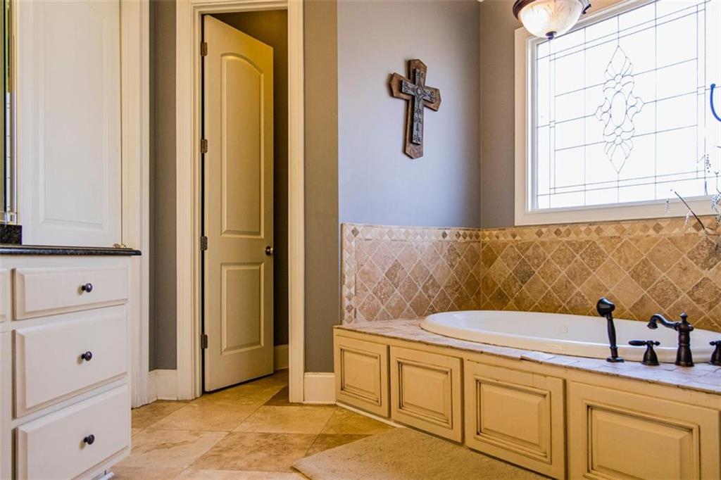 280 Ravenwood Drive Southeast Rome, GA 30161 - Photo 36 of 56 a bathroom with a granite countertop sink a mirror and a bathtub