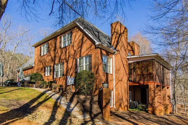 a view of a brick house with large windows and a outdoor space