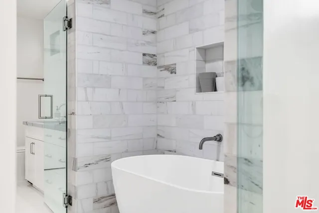 a bathroom with a granite countertop toilet sink and mirror
