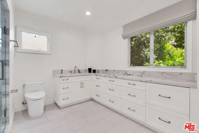 a bathroom with a double vanity sink mirror and shower