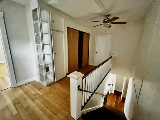 a view of a hallway with wooden floor and staircase