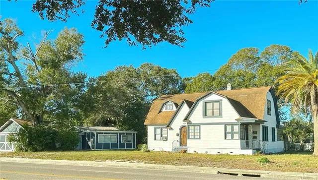 a view of a big house with a big yard and large trees