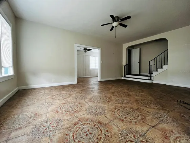 an empty room with fan and windows