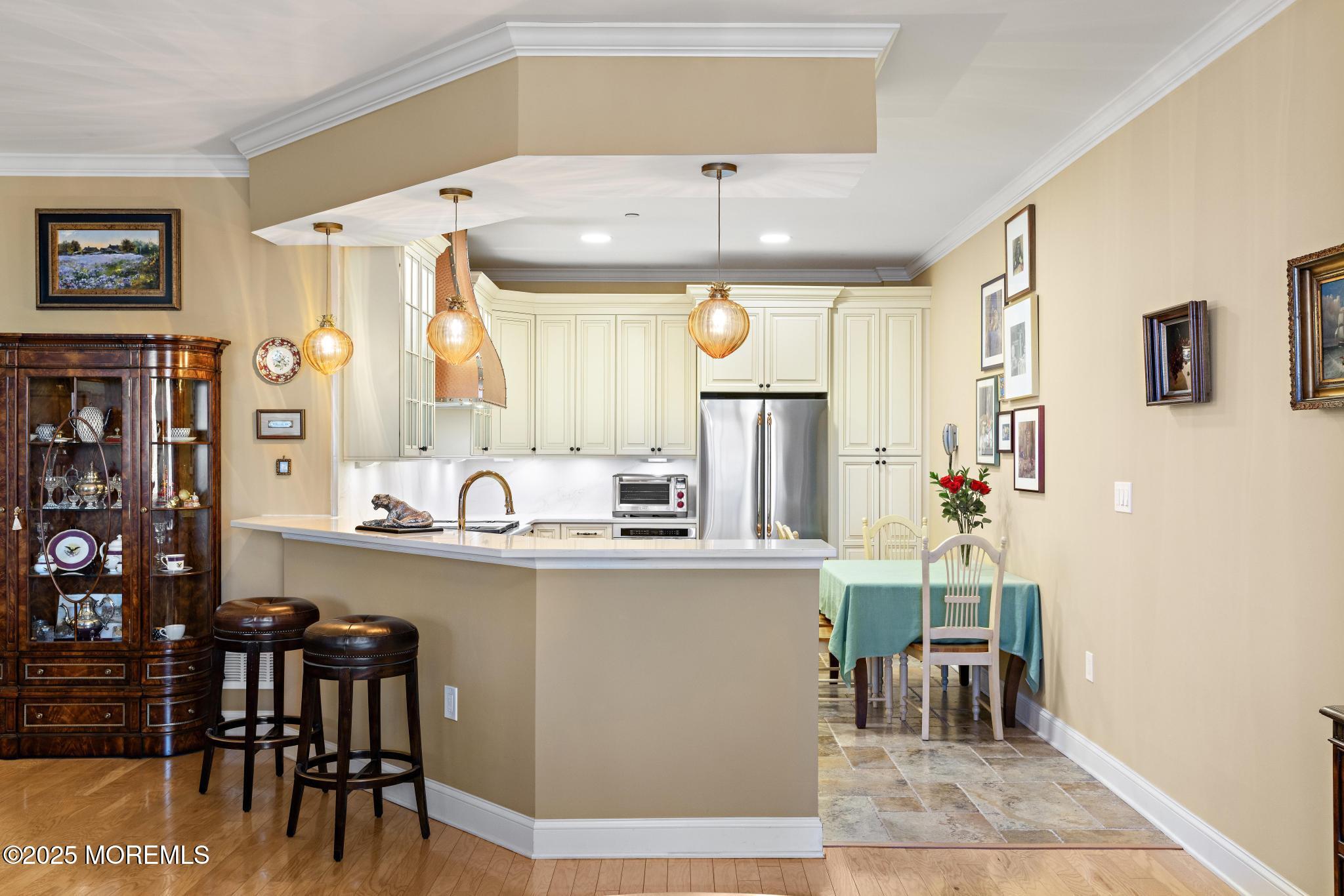 1501 Ocean Avenue, Unit 2112 Asbury Park, NJ 07712 - Photo 12 of 43 a kitchen with stainless steel appliances granite countertop a table chairs and a refrigerator