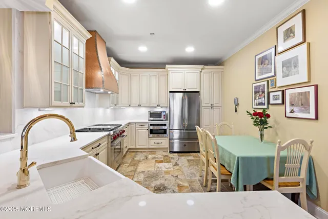 a large kitchen with stainless steel appliances granite countertop a sink and a refrigerator