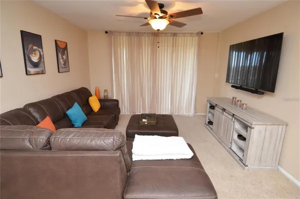 a spacious bedroom with a bed a window and a flat screen television