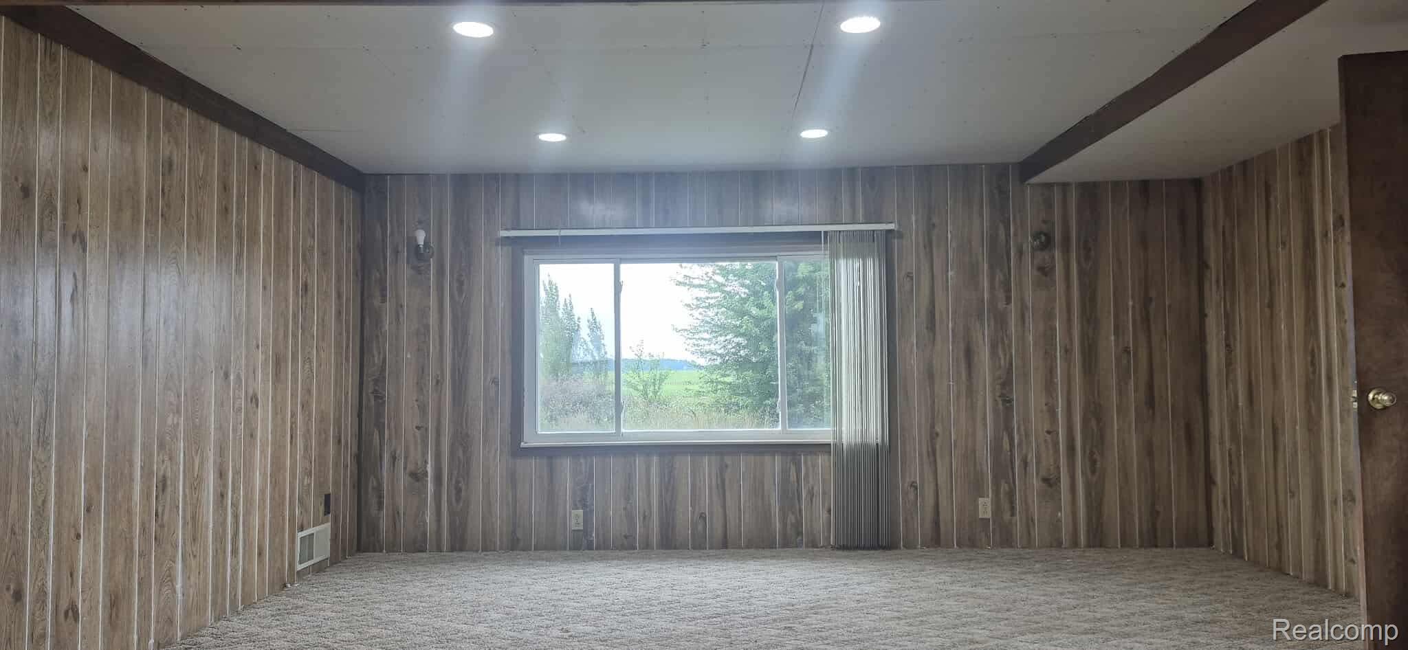 6935 Sanilac Road Marlette, MI 48453 - Photo 22 of 23 Carpeted empty room with recessed lighting and wood walls