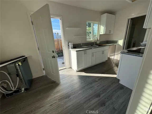 a view of a kitchen with fridge and wooden floor