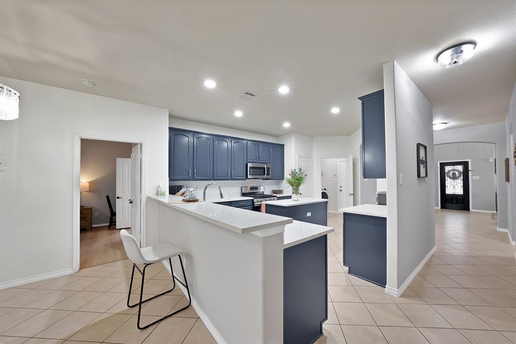 3822 Spring Run Lane Melissa, TX 75454 - Photo 13 of 39 a kitchen with a sink a refrigerator and chairs