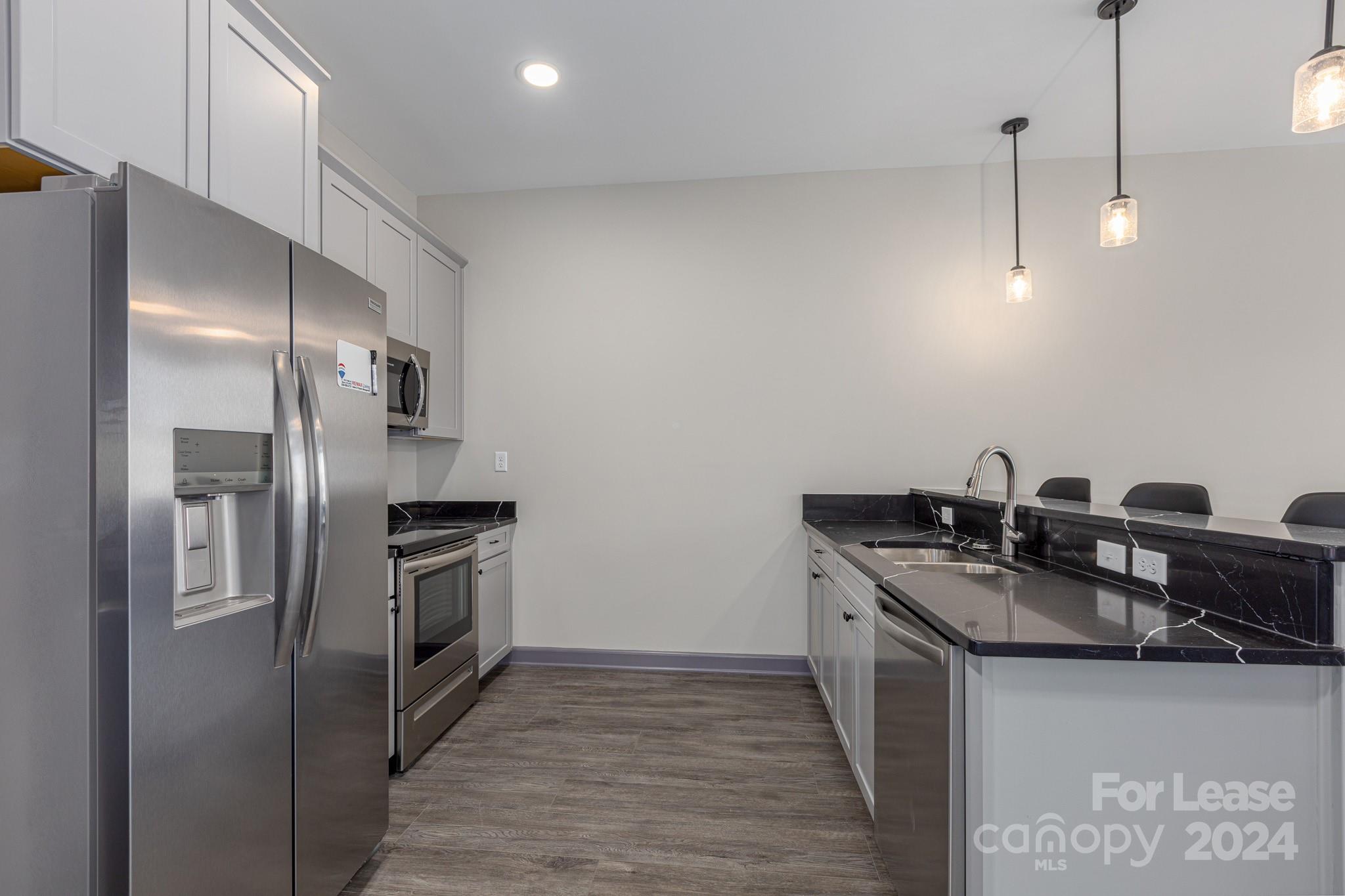 138 South Main Street, Unit D Marion, NC 28752 - Photo 2 of 11 a kitchen with stainless steel appliances granite countertop a sink stove and refrigerator