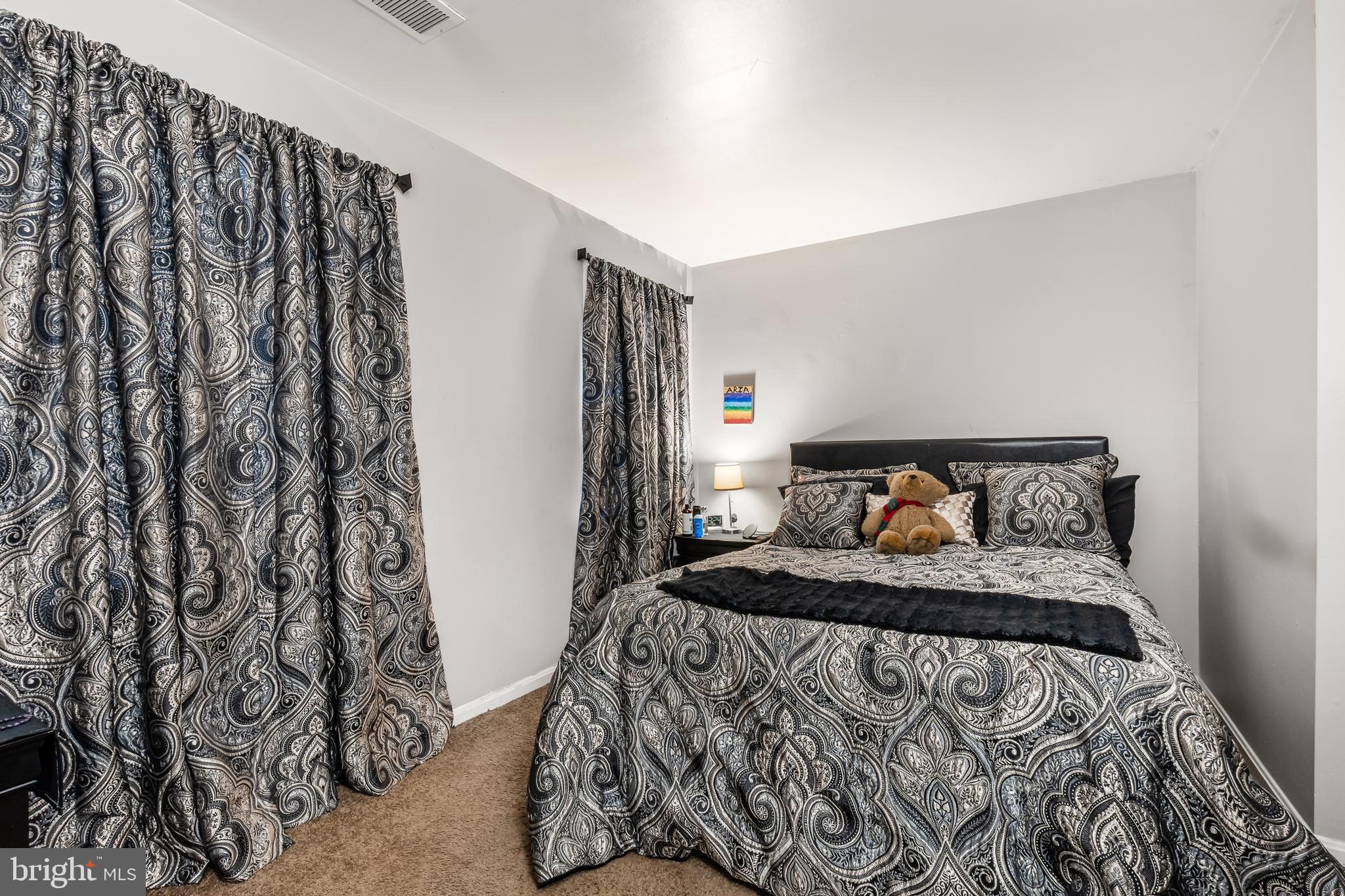 3814 V Street Southeast, Unit 101 Washington, DC 20020 - Photo 14 of 19 a bed sitting in a bedroom next to a window with cabinets