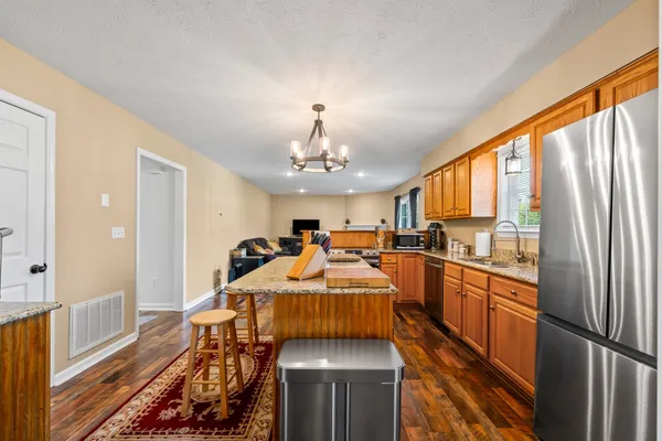 a living room with furniture a flat screen tv and kitchen view