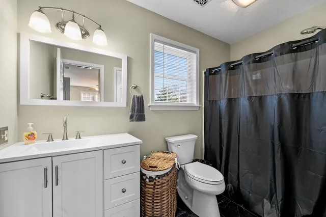 a city street lined with tall buildings and cars parked on the roadside