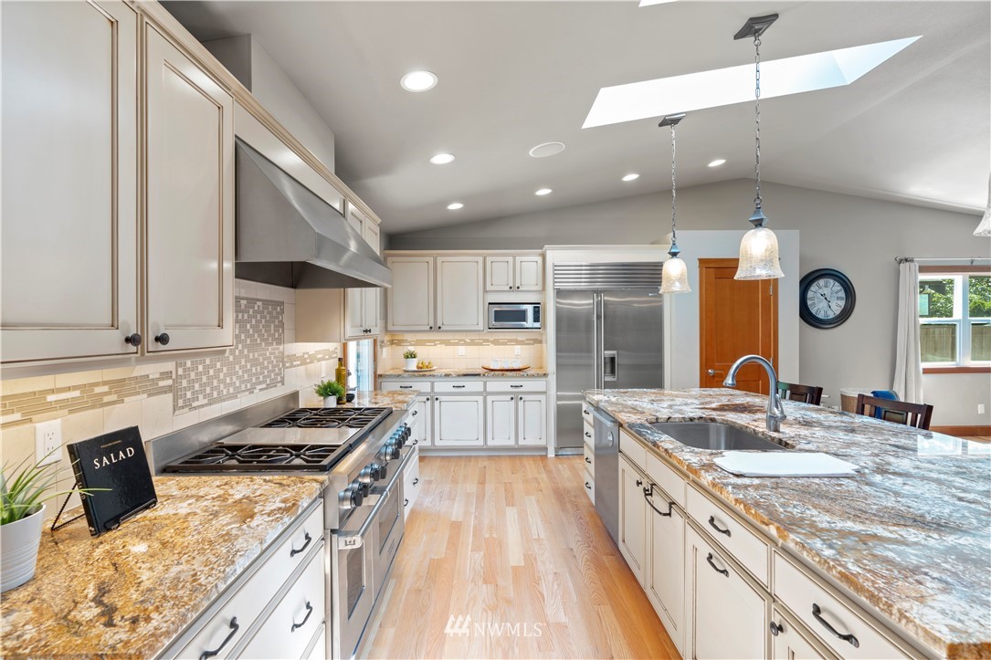 5 Winesap Road Bothell, WA 98012 - Photo 8 of 25 a large kitchen with kitchen island a large counter space a sink stainless steel appliances and cabinets