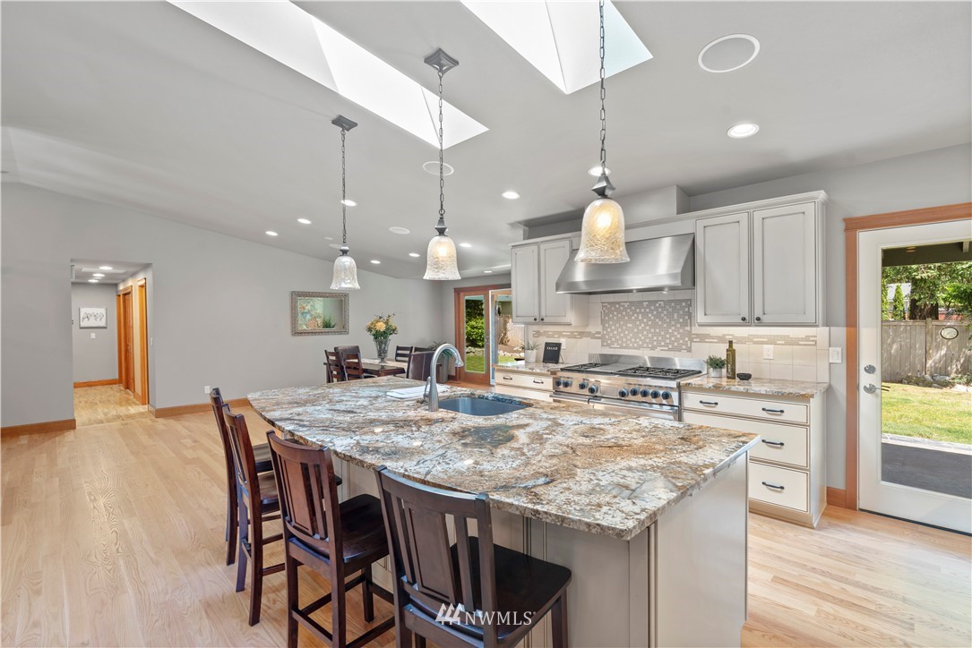 5 Winesap Road Bothell, WA 98012 - Photo 9 of 25 a kitchen with kitchen island a stove a table and chairs in it