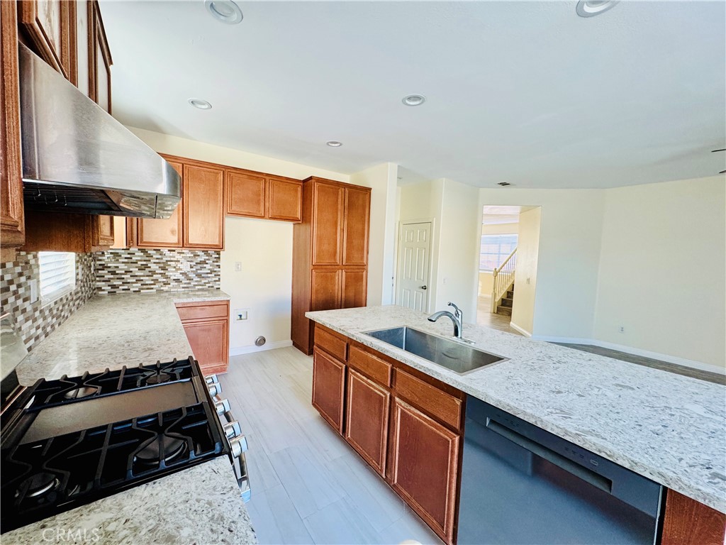 9329 Sable Ridge Avenue Hesperia, CA 92345 - Photo 11 of 31 a kitchen with stainless steel appliances granite countertop a sink stove and cabinets