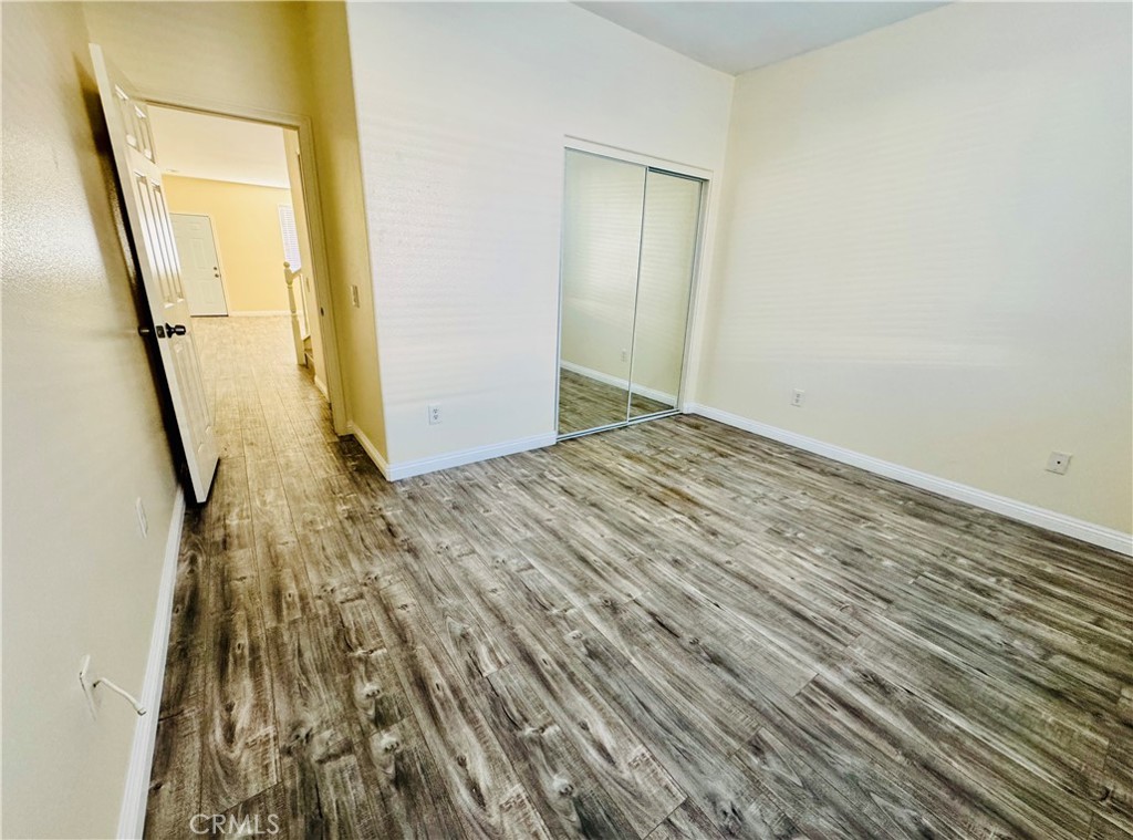 9329 Sable Ridge Avenue Hesperia, CA 92345 - Photo 17 of 31 a view of an empty room with wooden floor and a bathroom