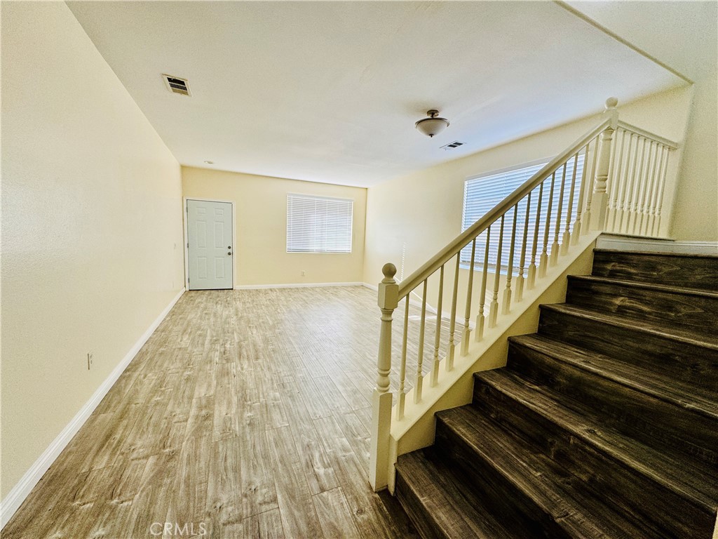 9329 Sable Ridge Avenue Hesperia, CA 92345 - Photo 18 of 31 a view of a hallway with wooden floor and staircase