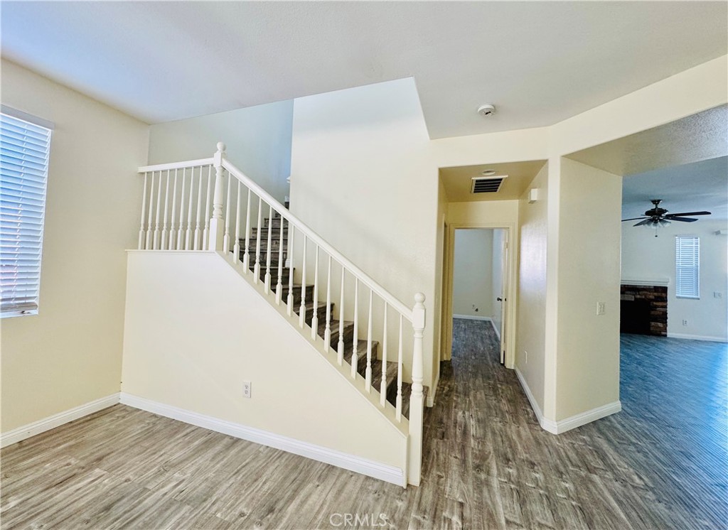 9329 Sable Ridge Avenue Hesperia, CA 92345 - Photo 2 of 31 a view of a hallway with wooden floor and staircase