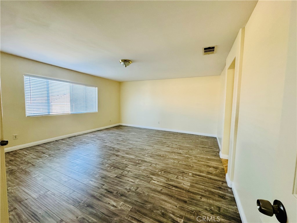 9329 Sable Ridge Avenue Hesperia, CA 92345 - Photo 22 of 31 a view of an empty room with wooden floor and a window