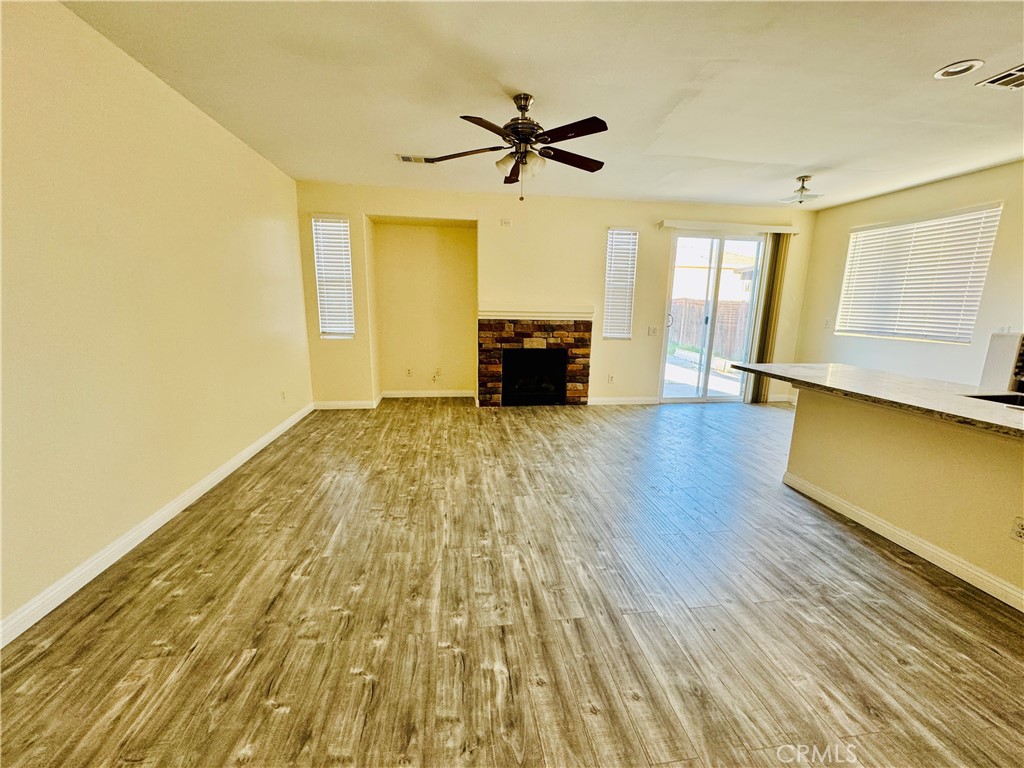 9329 Sable Ridge Avenue Hesperia, CA 92345 - Photo 4 of 31 a view of a livingroom with wooden floor and a ceiling fan