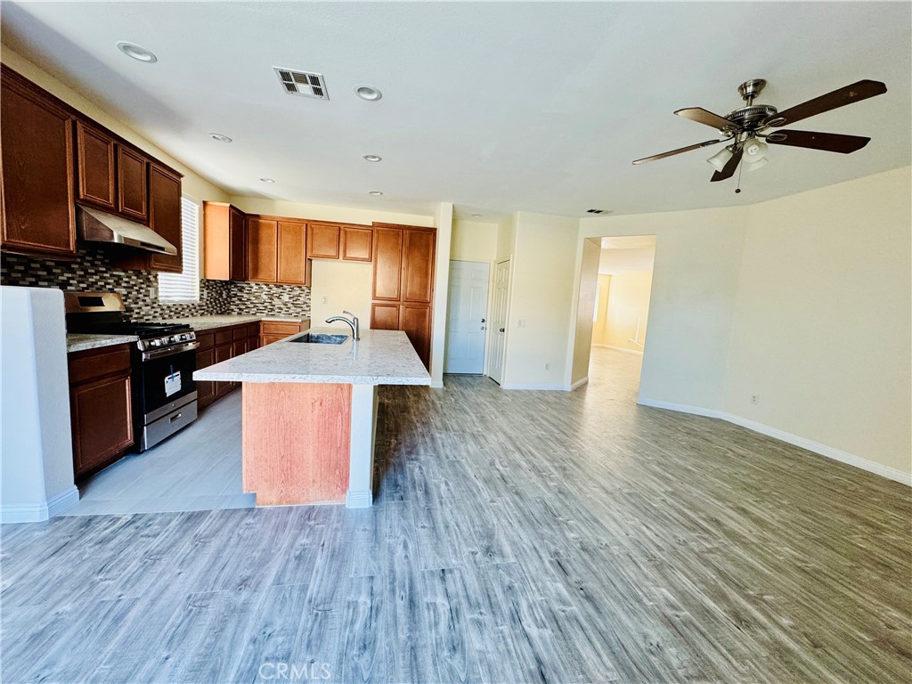 9329 Sable Ridge Avenue Hesperia, CA 92345 - Photo 8 of 31 a kitchen with stainless steel appliances granite countertop wooden floors and granite counter tops