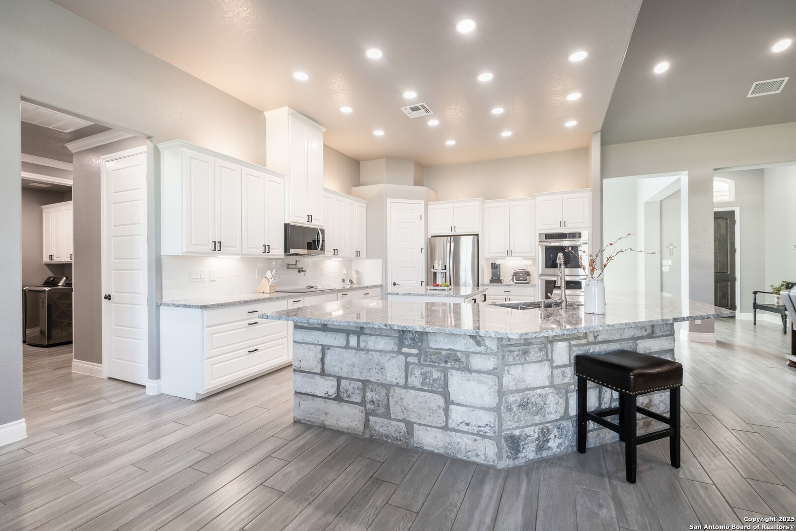 108 Timber Heights La Vernia, TX 78121 - Photo 16 of 42 a large kitchen with kitchen island white cabinets and stainless steel appliances