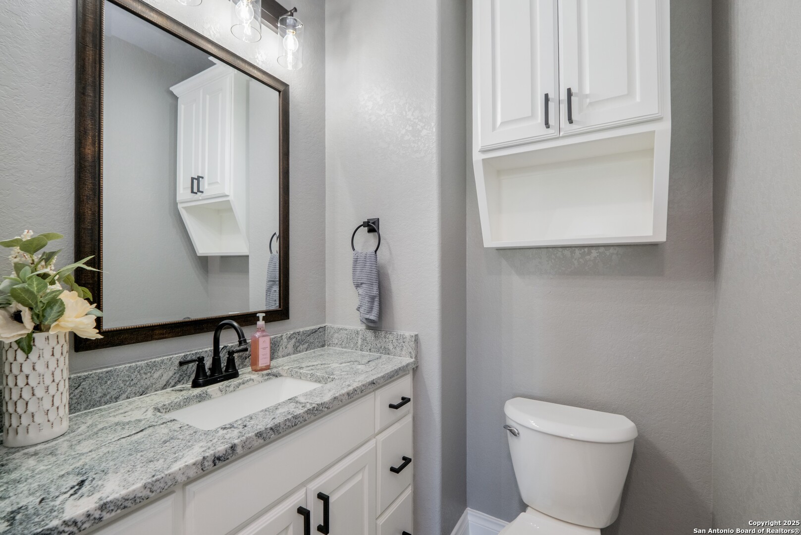 108 Timber Heights La Vernia, TX 78121 - Photo 24 of 42 a bathroom with a granite countertop toilet sink and mirror