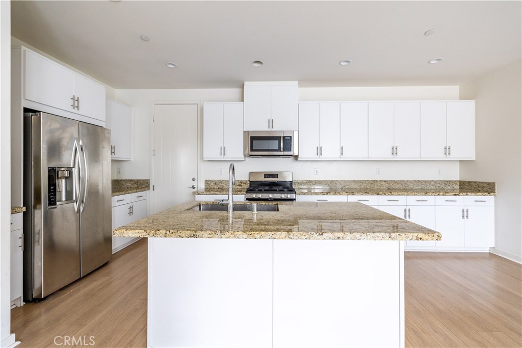 24 Prominence Lake Forest, CA 92630 - Photo 7 of 31 a kitchen with granite countertop a refrigerator and a stove top oven