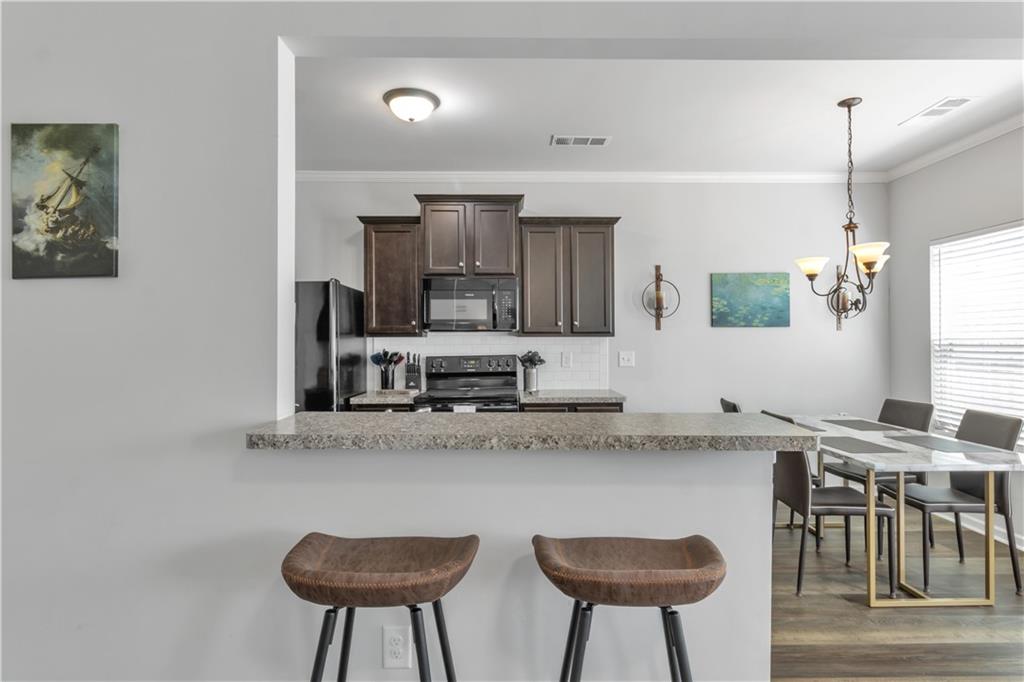 265 Valley Crossing Canton, GA 30114 - Photo 12 of 31 a kitchen with stainless steel appliances granite countertop a kitchen island and chairs in it
